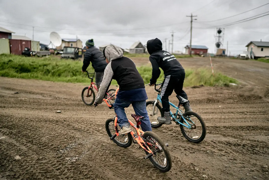 alaskan native children on bicycles in village